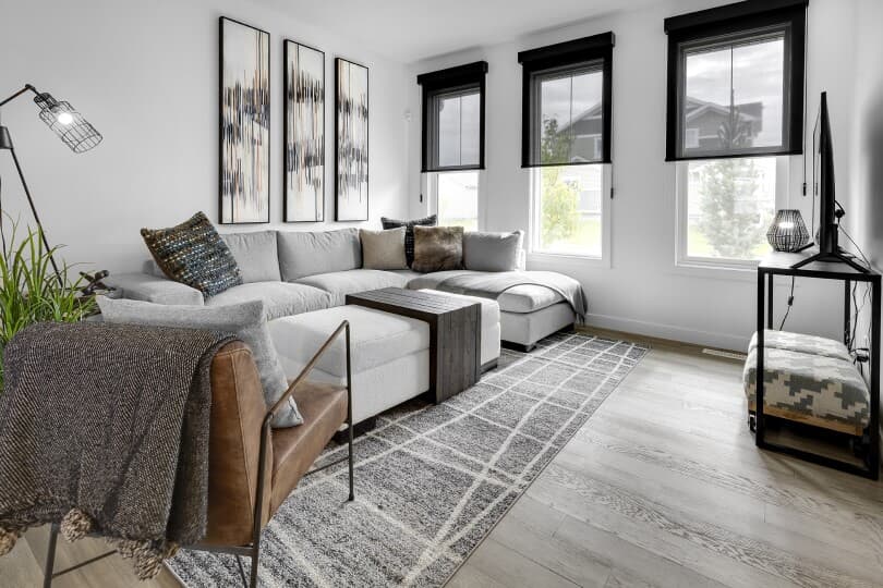 Grey sofa in the living area in Eton at Chappelle Gardens by Brookfield Residential in Edmonton, AB