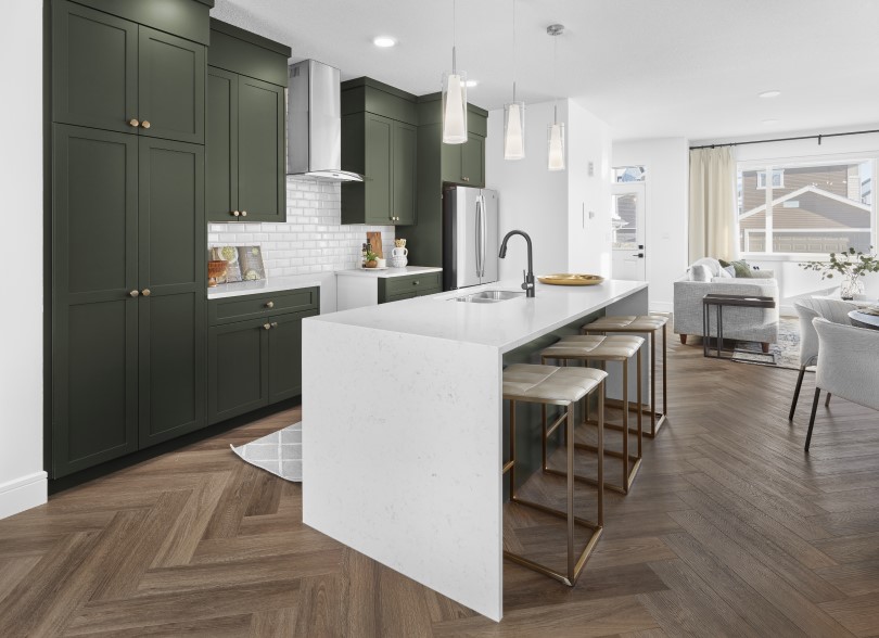 Dark green kitchen with waterfall countertop island in Asher at The Orchards in Edmonton, AB