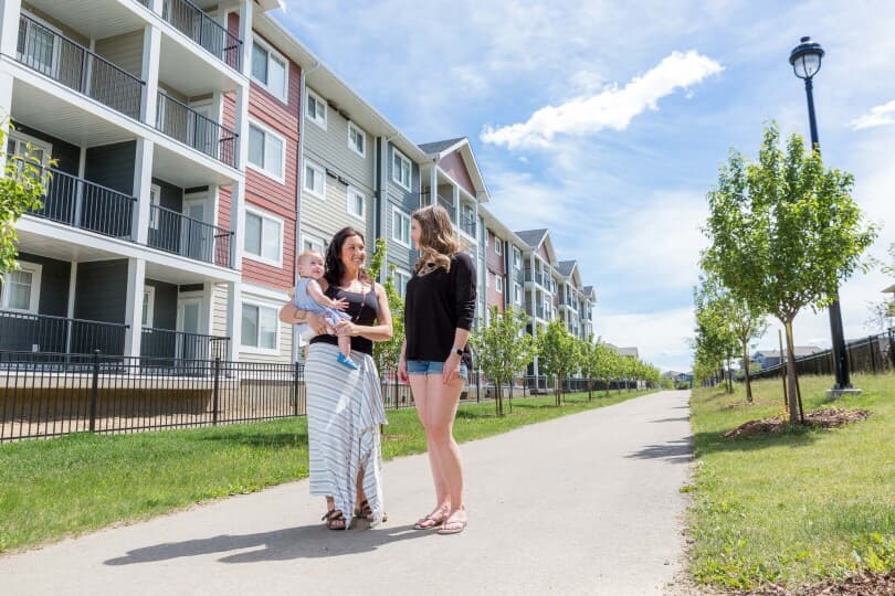 Two women chatting in front of the homes at Chappelle Gardens in Southwest Edmonton by Brookfield Residential
