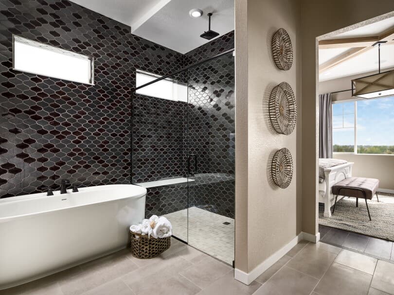 Spa-style bathroom with tub and overhead shower in an Ovation Portfolio home