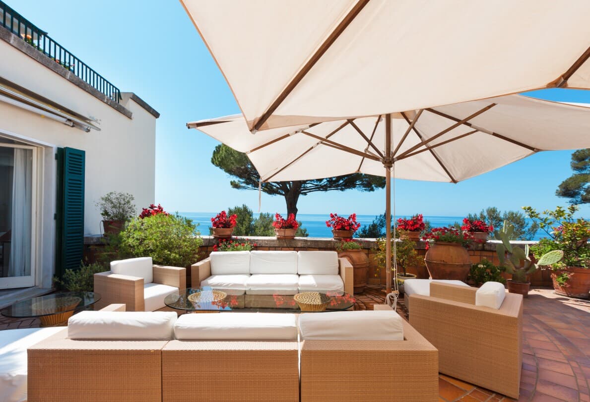 Outdoor living area with seating and umbrellas with an ocean view