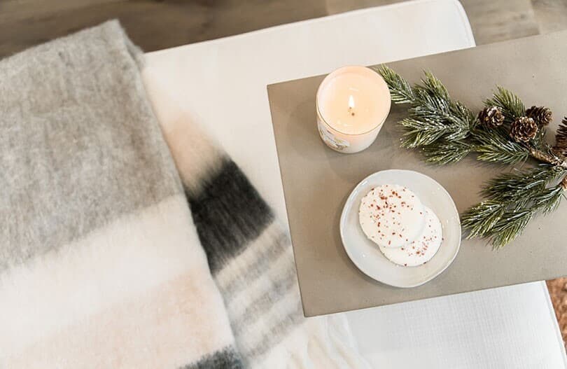 Cozy setting with a blanket candle and cookies