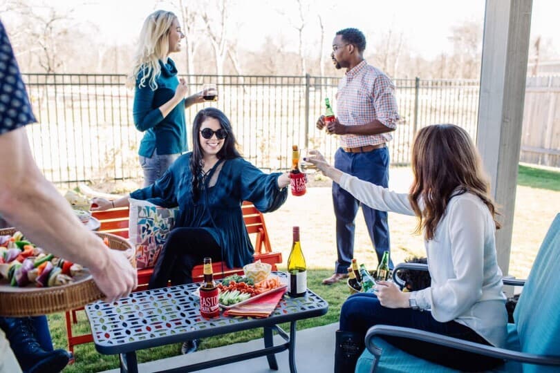 Friends enjoying food and drinks on a patio in Easton Park by Brookfield Residential in Austin TX