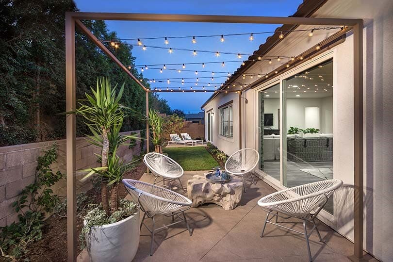 Outdoor space with seating and string lights at Shutters at Edenglen by Brookfield Residential in Ontario Ranch, CA