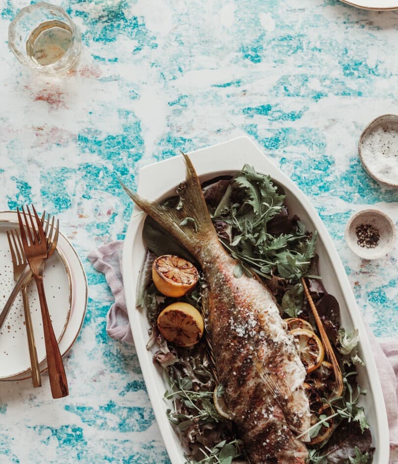 Whole grilled fish with lemon and greens