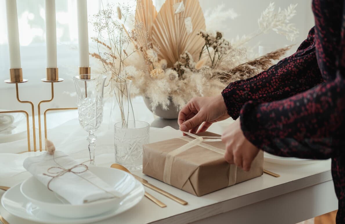 Close up photo of woman hands setting the table and preparing gifts