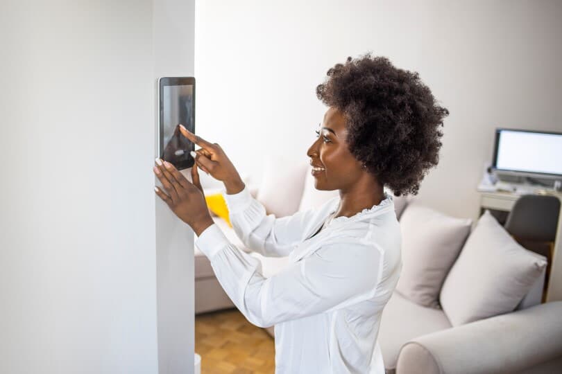 Woman using a wall mounted smart home system