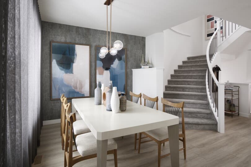 Dining area with wallpaper and curved staircase in a Brookfield Residential home