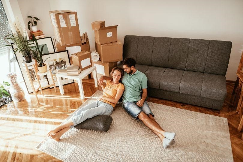 Concept of family sitting on floor of a new home with moving boxes