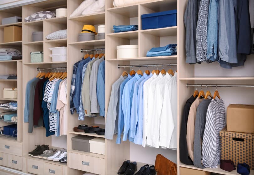 Large walk in closet organized with male clothing