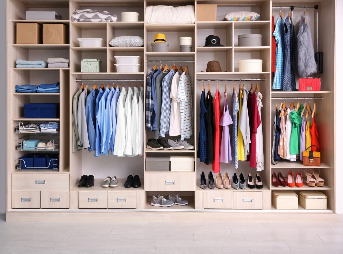 Organized closet with clothing and bins
