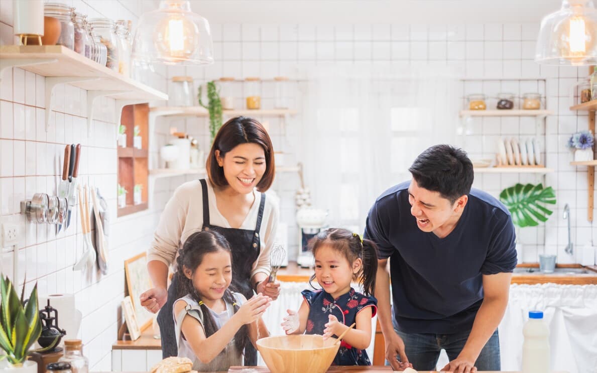 Young family mixing dry baking ingredients in a light and bright kitchen