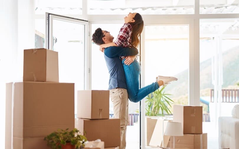 Couple in their new home surrounded by moving boxes