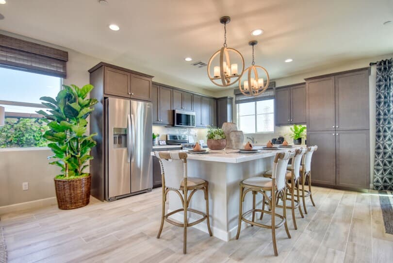 Kitchen with dark cabinets with white island at New Haven in Ontario Ranch, Southern California