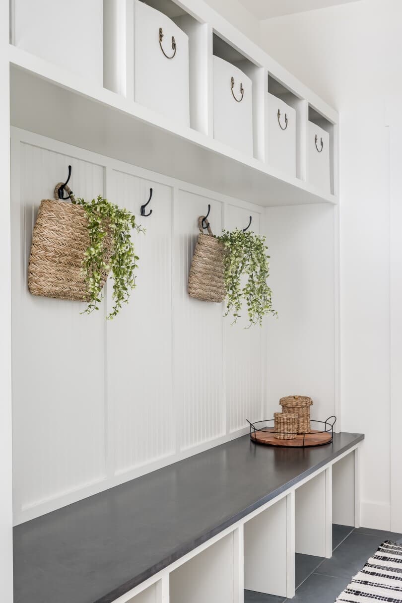 White mudroom with cubbies and bins
