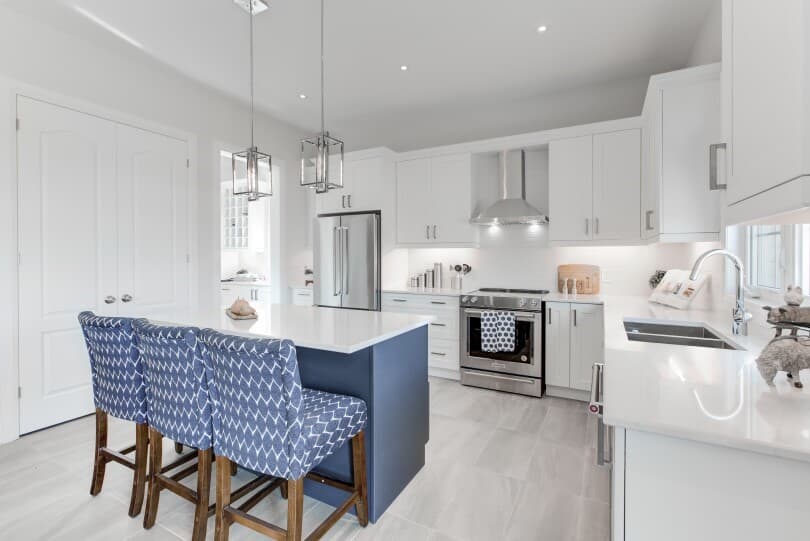 White kitchen with blue island in The Signature Collection at Woodhaven in Aurora, ON