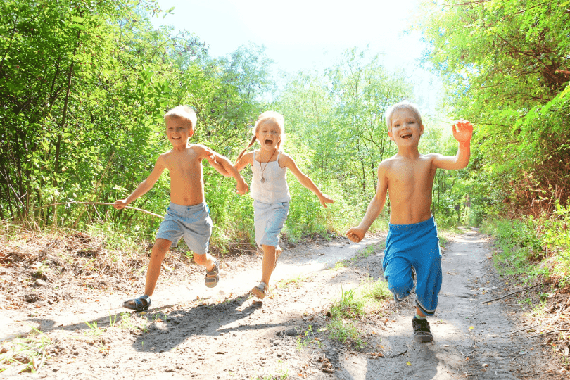 Kids running on forest pathway in the summertime