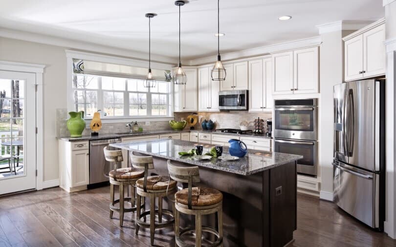 White kitchen with dark island in Beckner at Two Rivers in Odenton, MD