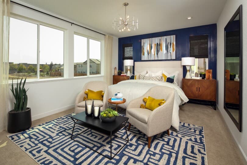 Primary bedroom with blue accent wall in Residence 6 at Chandler in Brentwood, CA