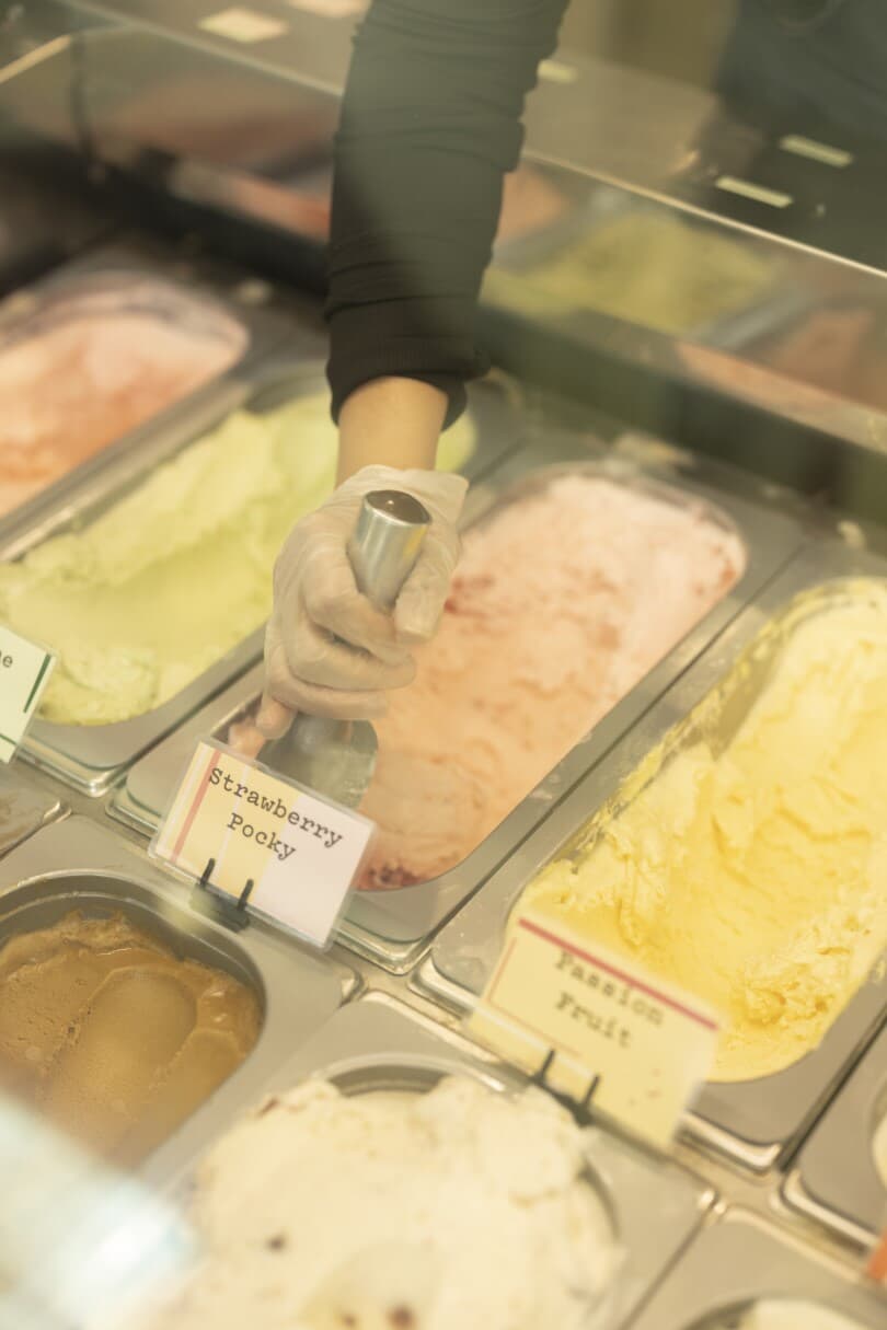 Hand scooping strawberry ice cream at Fika Fika Creamery in Ontario Ranch, CA