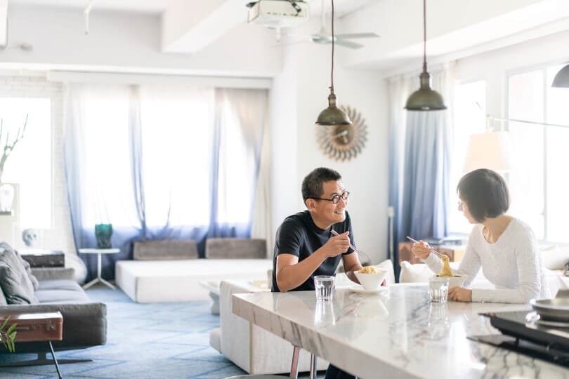 Couple eating dinner together in a modern home with big bright windows