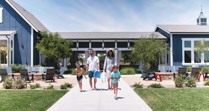 Family walking to the pool at Audie Murphy Ranch by Brookfield Residential in Menifee, CA