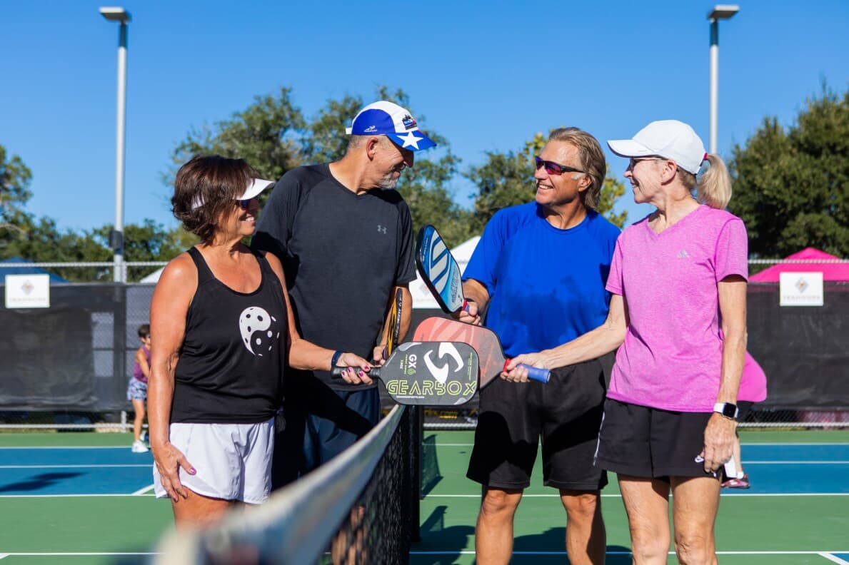 Group of four friends getting ready to play a game of pickleball at Kissing Tree in San Marcos, TX