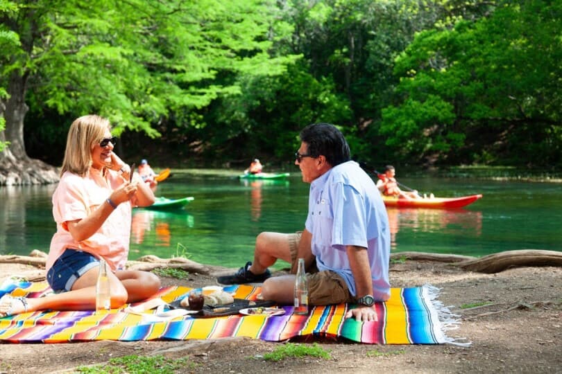 Couple having a picnic waterside in Texas